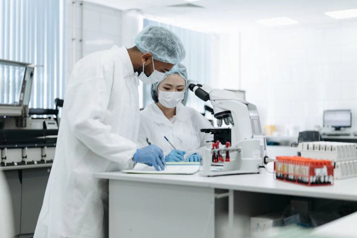 Two biotechnology researchers documenting laboratory work together